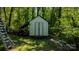 Small storage shed with a lean-to on a tree-filled lot with equipment nearby at 403 3Rd Nw St, Conover, NC 28613