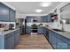 Modern kitchen featuring blue cabinets, stainless steel appliances, and granite countertops at 4148 Shasta Cir, Clover, SC 29710