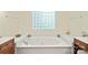 Bathroom featuring a large tub with tile surround and glass block window at 4232 Shannamara Dr, Matthews, NC 28104