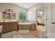 A relaxing bathroom showcasing a soaking tub with wooden finish and a vanity with drawers at 425 W North Corner Rd, Lancaster, SC 29720