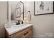 A bright half bath featuring wood cabinets, a modern mirror and white quartz countertop at 425 W North Corner Rd, Lancaster, SC 29720