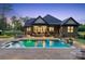 Inviting pool area with a stone patio, outdoor seating, and lush landscaping at 425 W North Corner Rd, Lancaster, SC 29720
