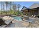 Lovely backyard pool area featuring a stone fire pit, lounge chairs, and a built-in outdoor grill at 425 W North Corner Rd, Lancaster, SC 29720