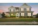 Charming two-story home featuring a welcoming front porch, well-manicured lawn, and classic black shutters at 4321 Hornyak Dr, Monroe, NC 28110