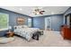 This spacious bedroom features blue walls, a ceiling fan, and carpeted floors at 4506 S Potter Rd, Monroe, NC 28112