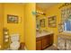 This bright yellow bathroom includes a toilet, cabinet and shelving for storage and decor at 4810 Shea Ct, Monroe, NC 28110