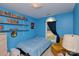 Cozy bedroom with blue walls, shelving with comic books, and a window with natural light at 4810 Shea Ct, Monroe, NC 28110