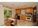 Eat-in kitchen features wood cabinets, updated appliances, tile countertops, and backyard views at 4810 Shea Ct, Monroe, NC 28110