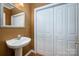 Elegant powder room with pedestal sink, decorative mirror and fresh white paint at 510 N Alexander St, Charlotte, NC 28202