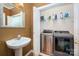 Bathroom/laundry room combination featuring washer and dryer, sink, and storage shelves at 510 N Alexander St, Charlotte, NC 28202