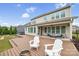 A spacious back yard with a wooden deck, outdoor chairs, fire pit, hot tub and a lush lawn at 528 Rock Skip Way, Fort Mill, SC 29708