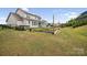A lush backyard with a vegetable garden, a wooden patio, and a view of the two-story home at 528 Rock Skip Way, Fort Mill, SC 29708