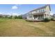 A manicured backyard featuring a patio with seating, a fire pit, a garden, and lush green grass at 528 Rock Skip Way, Fort Mill, SC 29708