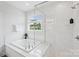 Spacious white tiled bathroom with a soaking tub and glass-enclosed shower at 528 Rock Skip Way, Fort Mill, SC 29708