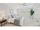 Bright bedroom features a decorative mirror, ceiling fan, and large windows with a view at 528 Rock Skip Way, Fort Mill, SC 29708