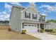 Green two-story home with an attached two-car garage and manicured front lawn at 6070 Trinity Crossing Cir, Kannapolis, NC 28081