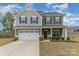 Charming two-story home with a well-manicured lawn, attached garage and beautiful landscaping at 6070 Trinity Crossing Cir, Kannapolis, NC 28081