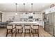 Bright kitchen featuring a large island with seating, white cabinets, and stainless steel appliances at 6070 Trinity Crossing Cir, Kannapolis, NC 28081