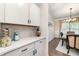 Kitchenette with white cabinets, quartz countertop, and eat-in dining area with chair rail detail at 6070 Trinity Crossing Cir, Kannapolis, NC 28081
