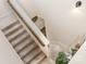 Carpeted staircase with wooden handrail and modern lighting, offering a bright and welcoming transition between floors at 6070 Trinity Crossing Cir, Kannapolis, NC 28081