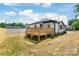 View of a wood deck and the home's exterior with a large, fenced-in backyard at 640 Central Nw Dr, Concord, NC 28027
