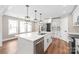 Kitchen featuring a large island with bar seating, stainless steel appliances, and white cabinetry at 640 Central Nw Dr, Concord, NC 28027