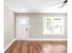 Living room with wood floors, neutral walls, and ample natural light from windows and a glass paneled front door at 640 Central Nw Dr, Concord, NC 28027