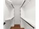 Walk-in closet features white shelving and wooden floors for storage at 640 Central Nw Dr, Concord, NC 28027