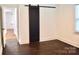 Bright bedroom with hardwood floors, a sliding barn door, and natural light from the window at 645 Wilshire Sw Ave, Concord, NC 28027