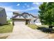 Home's exterior features a two-car garage, and stone detailing at 726 Centennial St, Gastonia, NC 28056