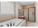 Elegant bathroom featuring a soaking tub, tiled shower, and decorative window at 7887 Mountain Shore Dr, Sherrills Ford, NC 28673