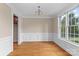 Dining room featuring hardwood floors, wainscoting, and large windows for natural light at 7887 Mountain Shore Dr, Sherrills Ford, NC 28673
