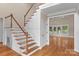 Elegant staircase with white wainscoting, hardwood steps, and a light-filled landing at 7887 Mountain Shore Dr, Sherrills Ford, NC 28673