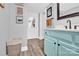 Bathroom with blue vanity, modern fixtures, wood floors, and decorative wall art at 803 N Walnut St, Kannapolis, NC 28081