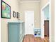 Hallway with light beige walls, wood laminate floors and a light blue dresser with drawers at 803 N Walnut St, Kannapolis, NC 28081