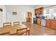 Spacious kitchen with wood cabinets, laminate floors, black appliances, dining table and view to another room at 803 N Walnut St, Kannapolis, NC 28081