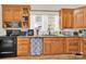 Traditional style kitchen with wood cabinets, black appliances, view of window, and ample counter space at 803 N Walnut St, Kannapolis, NC 28081