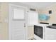 Functional laundry room with modern washer and dryer, door to outside, and storage at 803 N Walnut St, Kannapolis, NC 28081