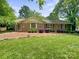 Charming single-story brick home with a well-manicured lawn and landscaped front yard at 828 N 6Th St, Albemarle, NC 28001