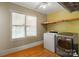 Laundry room with washer, dryer and storage shelves at 828 N 6Th St, Albemarle, NC 28001