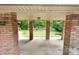View from the covered patio with brick columns and a green space at 828 N 6Th St, Albemarle, NC 28001