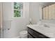 Bright bathroom features neutral paint, white vanity, and window with a green view at 8819 Kishorn Ct, Charlotte, NC 28215