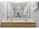 Bathroom with dual sinks, large mirror, and tub/shower with white tile at 8819 Kishorn Ct, Charlotte, NC 28215