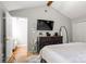 Primary bedroom featuring hardwood floors, vaulted ceilings, and a modern TV set at 8819 Kishorn Ct, Charlotte, NC 28215