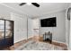 Secondary bedroom with closet, dark furniture, TV, and hardwood flooring at 8819 Kishorn Ct, Charlotte, NC 28215