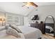 Bright primary bedroom with hardwood floors, TV, and cozy seating at 8819 Kishorn Ct, Charlotte, NC 28215