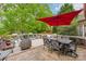 Relaxing outdoor deck space featuring a dining area, lounge seating, and a large red umbrella at 8905 Landsdowne Ave, Harrisburg, NC 28075