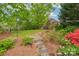 Picturesque backyard with stepping stones leading to a swing and lush landscaping at 8905 Landsdowne Ave, Harrisburg, NC 28075