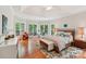 Bright main bedroom with tray ceilings, sitting area, and large windows at 8905 Landsdowne Ave, Harrisburg, NC 28075