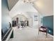 Bright bonus room with vaulted ceiling, built-in shelves, and space for an office setup at 8905 Landsdowne Ave, Harrisburg, NC 28075